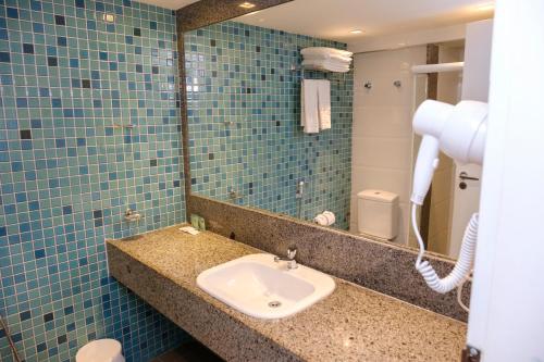 a bathroom with a sink and a mirror at Marante Plaza Hotel in Recife