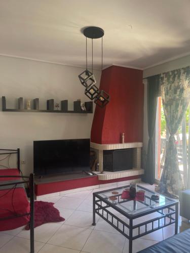 a living room with a fireplace and a glass table at Medusa Apartment in Artemida