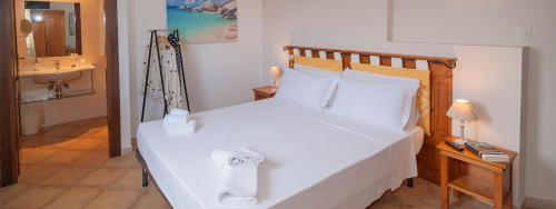 1 dormitorio con cama blanca y lavamanos en Sa Murta Bianca Guesthouse, en Budoni