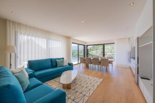 a living room with a blue couch and a table at Lajinha do Ave in Azevedos