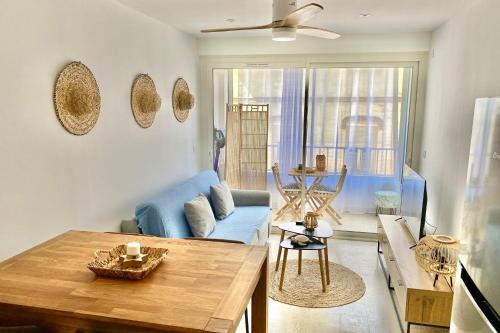 - un salon avec un canapé bleu et une table dans l'établissement Nouveau T2 Boheme Centre Ville Palavas Proche Mer, à Palavas-les-Flots