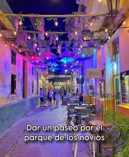a street with purple lights and people walking down a street at Aparta hotel aviva in Santa Marta