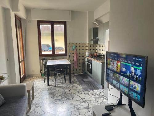 uma sala de estar com televisão e uma cozinha com mesa em SELENE CASA em Prato