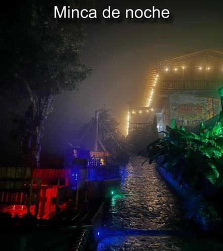 a nightime picture of a house with lights on the water at Aparta hotel aviva in Santa Marta