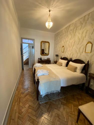 a bedroom with two beds and a chandelier at Pátio da Villa - Coruche Boutique Guest House in Coruche