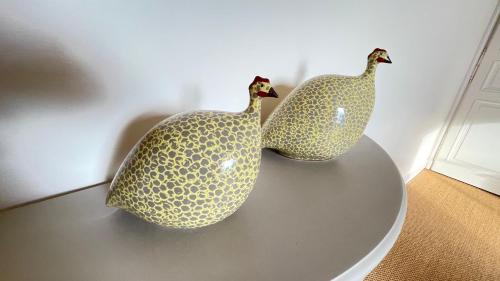 two sculptures of two birds sitting on a table at Le Clos de Paris in Fresnay-sur-Sarthe