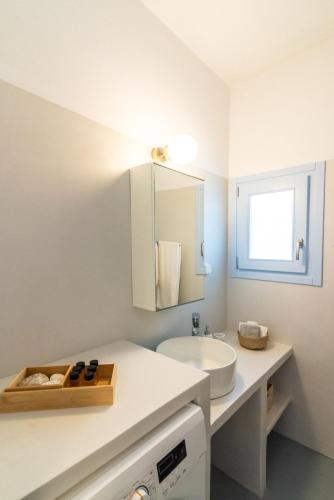 a white bathroom with a sink and a mirror at Light Blue House - Kato Kleisma in Káto Klísma