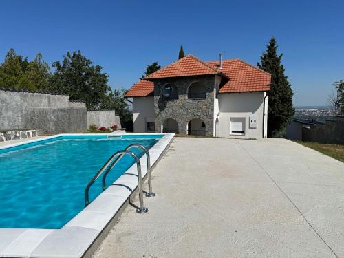 a swimming pool in front of a house at Vila ISKRA in Novi Sad