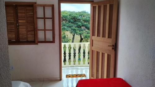 eine offene Tür mit Blick auf einen Balkon in der Unterkunft Pousada & Camping Recanto dos Anjos Azuis in Paty do Alferes