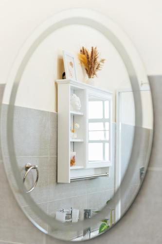 a bathroom mirror with a sink and a window at Golden View Manor in Naivasha