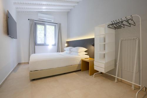 a white bedroom with a bed and a window at AEGEAN Apartments - Bungalows in Alaçatı