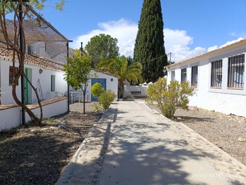 un marciapiede davanti a due edifici bianchi di Cortijo Don Rodrigo a El Chorro