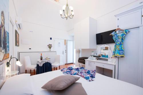 una camera bianca con un letto e una sala da pranzo di Hotel Antica Repubblica in Amalfi center at 100mt from the sea with payment parking ad Amalfi