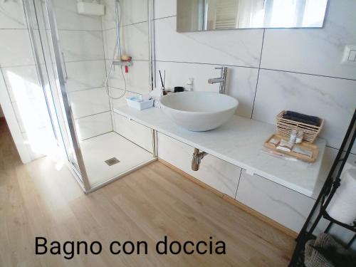 ein Badezimmer mit einem weißen Waschbecken und einer Dusche in der Unterkunft La Casa di Mimi' ( intero monolocale) in Legnano