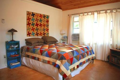 a bedroom with a bed with a colorful quilt on it at Above Sleepy Hollow - A Hidden Getaway in Hedgesville