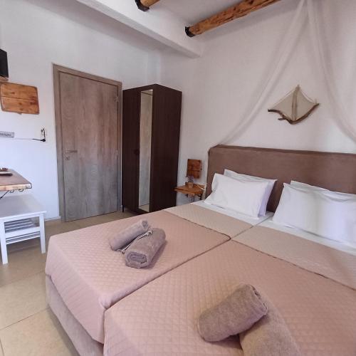 a bedroom with a large bed with towels on it at Mariza Apartments -studios in Hanioti