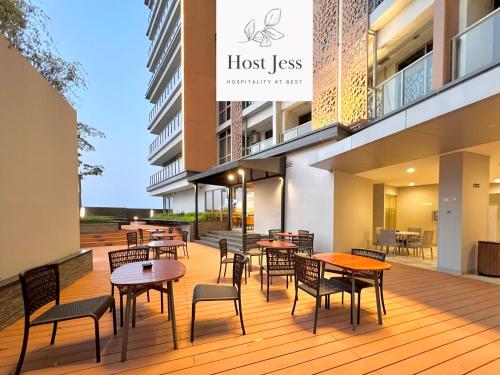a deck with tables and chairs on a building at Gold Coast PIK Apartments by Host Jess in Jakarta