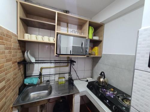 a small kitchen with a sink and a microwave at Hospedaje Casa Huayra in Cusco