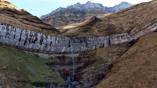 an aerial view of a mountain with a waterfall at La cabaña mirador de los Valles Pasiegos in Vega de Pas
