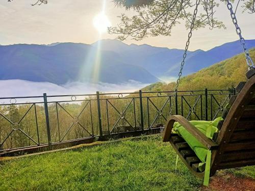a bench swing with a view of a mountain at La cabaña mirador de los Valles Pasiegos in Vega de Pas
