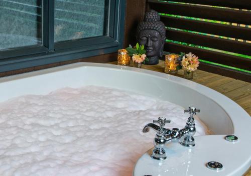 a bath tub filled with water next to a statue at Broadoaks Boutique Country House in Windermere