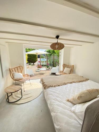a bedroom with a large bed and a chair at Tranquil Guest House in Zandvoort