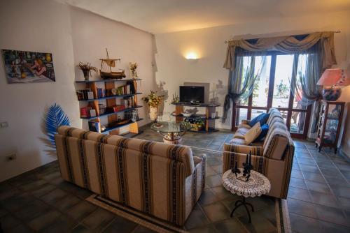 Sala de estar con 2 sofás y mesa en Villa By The Beach, en SantʼAndrea