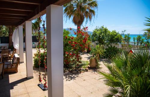 un patio con flores y vistas al océano en Villa By The Beach, en SantʼAndrea