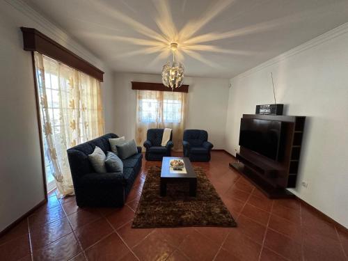 a living room with a couch and a tv at Vila Teixeira in Amarante