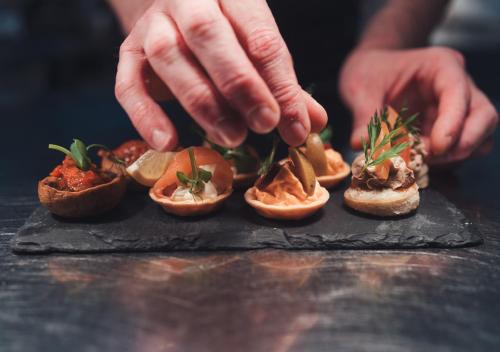 a person is putting toppings on a bunch of food at Broadoaks Boutique Country House in Windermere