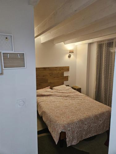 une chambre avec un lit avec une tête de lit en bois dans l'établissement La Bergerie, à Narbonne