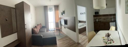 a small living room with a table and a kitchen at Apartman Valnela in Veľká Lomnica