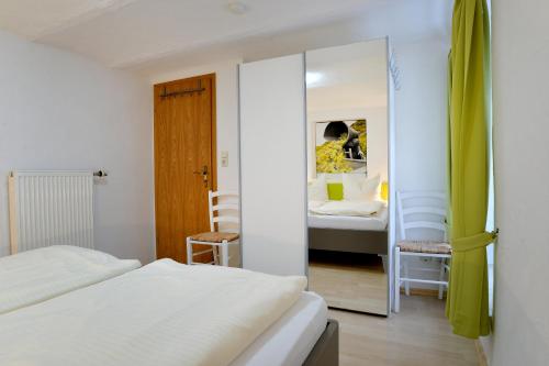 a bedroom with two beds and a mirror at Ferienwohnungen by Weingut Hommes in Ernst Mosel in Ernst