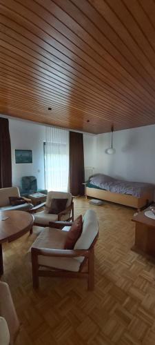 a living room with a bed and a couch and tables at Haus Am Teich Oetjens in Weilburg_Gaudernbach