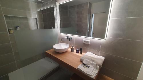 une salle de bain avec un lavabo, un miroir et une baignoire dans l'établissement Appartement moderne Strasbourg, à Strasbourg