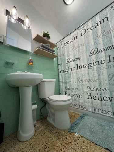 a bathroom with a white toilet and a sink at Casa Bohemia, Villalba in Palma Sola