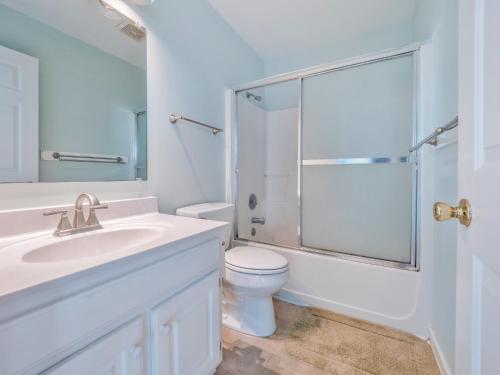 a bathroom with a toilet and a glass shower at A Grande Green in Surf City
