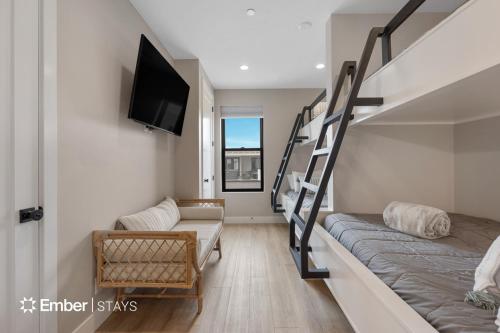a small room with a bunk bed and a tv at The Solace at Desert Color by Ember Stays in St. George
