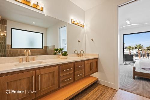 a bathroom with two sinks and a large mirror at Baseball Beach House at Desert Color (by Ember Stays) in St. George