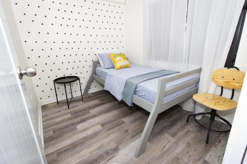 a small bedroom with a bed and two stools at Isabela on the Cliff in Isabela