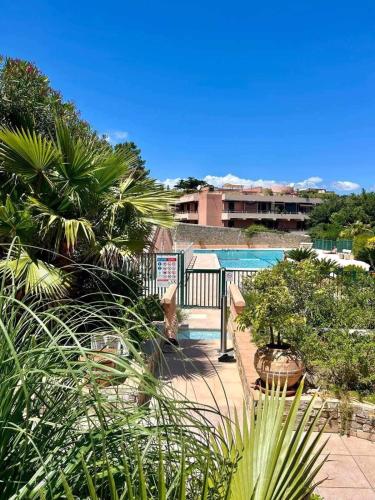 une vue d'une piscine avec un banc et des plantes dans l'établissement Heraclee, à Saint-Tropez