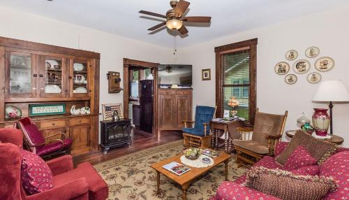 a living room filled with furniture and a ceiling fan at Mistletoe House in Fredericksburg