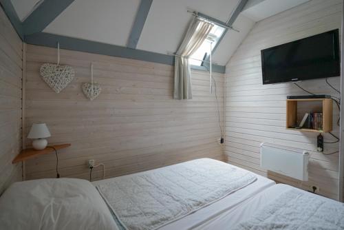 Schlafzimmer mit einem Bett und einem Flachbild-TV in der Unterkunft Ferienhaus am See im Bergland "Schmetterling" in Kirchheim