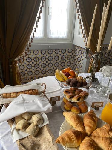 a table with a bunch of bread and pastries on it at Pátio da Villa - Coruche Boutique Guest House in Coruche