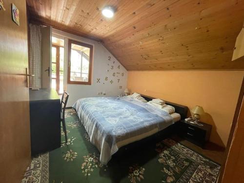 a bedroom with a bed and a wooden ceiling at Jezero apartment in Palić