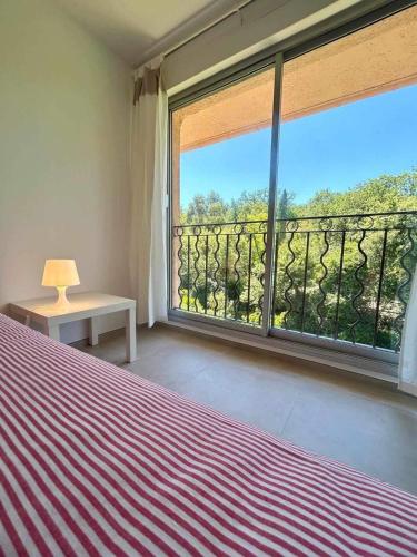 une chambre avec un lit et une grande fenêtre dans l'établissement Heraclee, à Saint-Tropez
