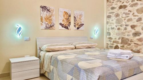 1 dormitorio con 1 cama y pinturas en la pared en Casa Nina - 10' dalla spiaggia en Gonnesa