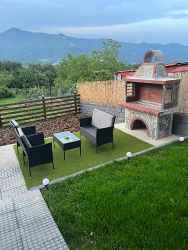 a patio with two chairs and a stone fireplace at ElatoVillage in Elatochori