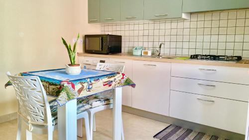una cocina con una mesa con una planta en Casa Nina - 10' dalla spiaggia en Gonnesa