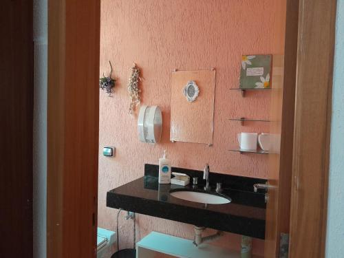 y baño con lavabo y espejo. en Flats Santa Genoveva, en Goiânia